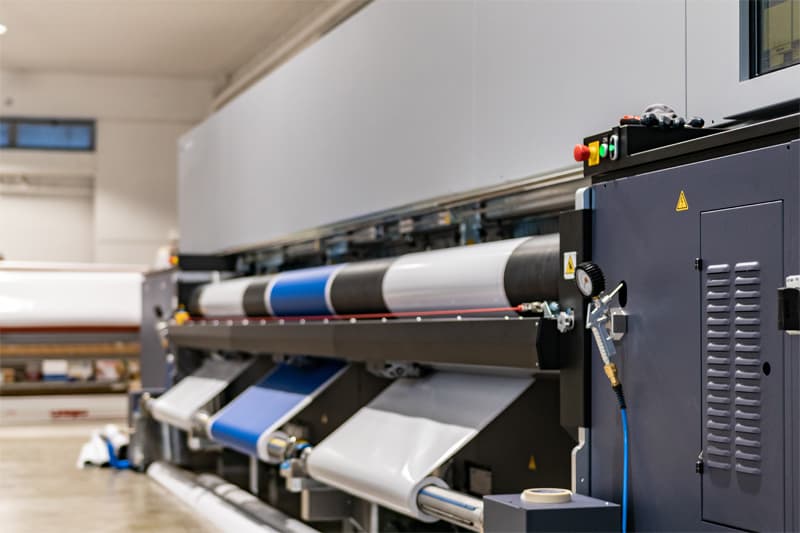 Large-format printer with rolls of vinyl, fabric, and other materials